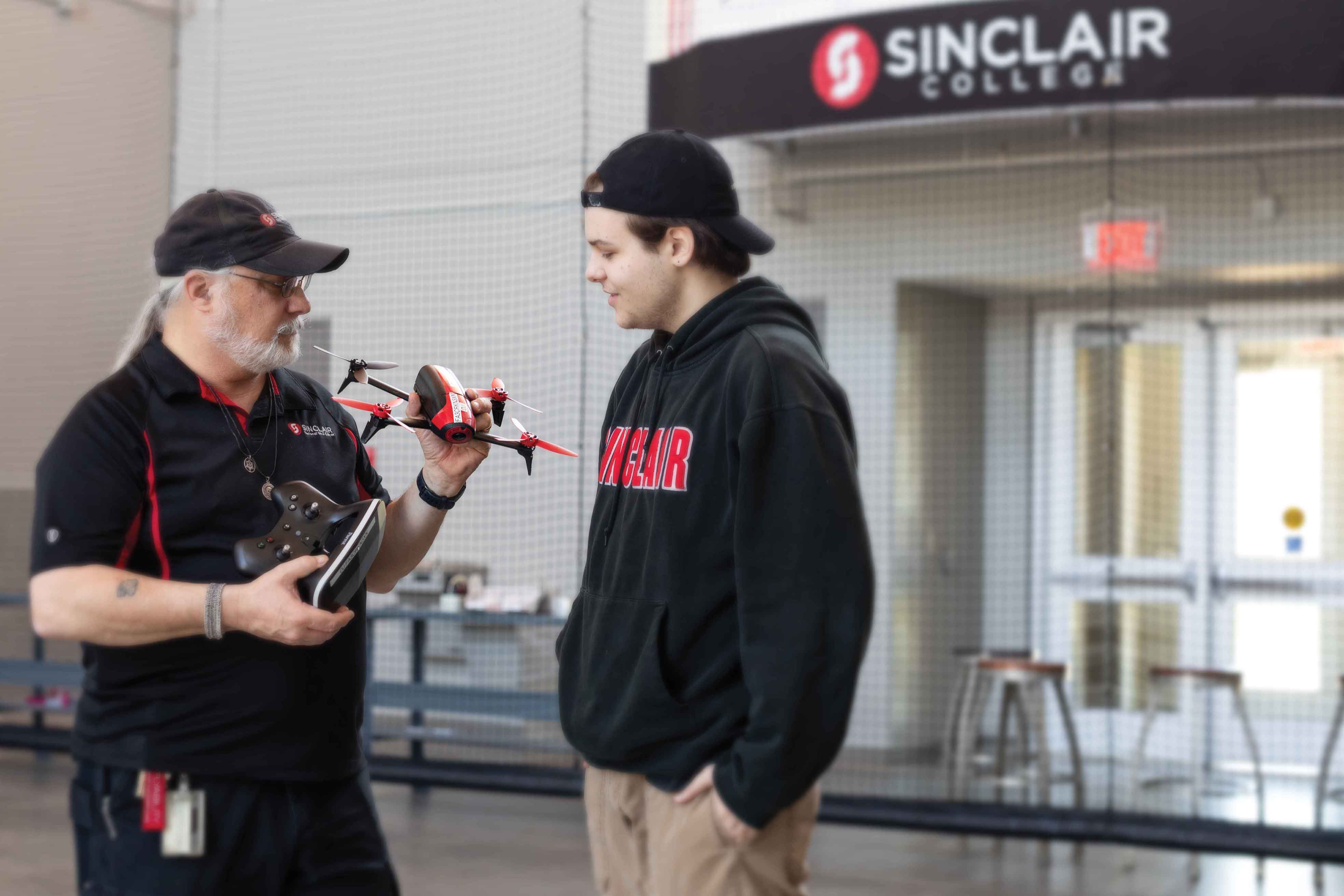 Sinclair instructor showing a drone to a student.