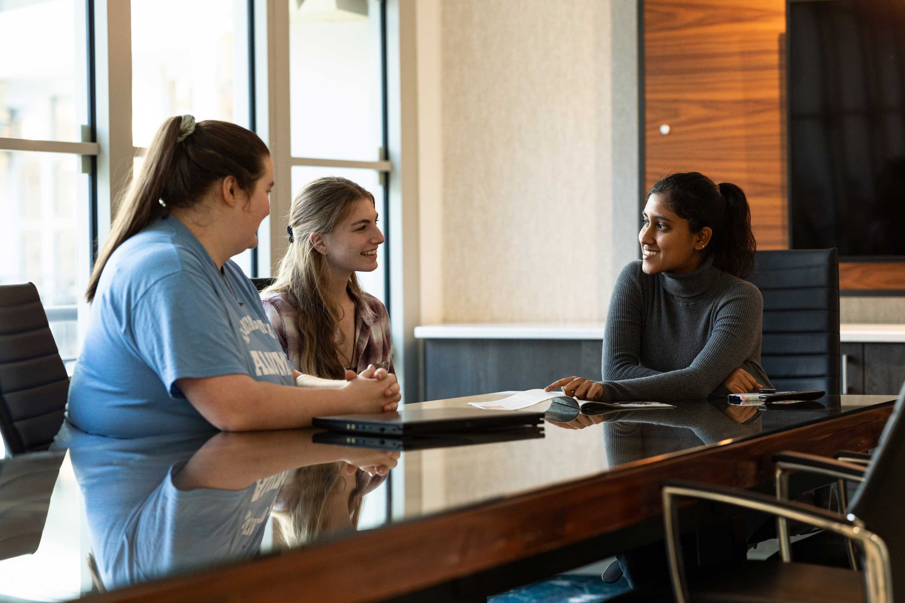 A diverse group of students collaborating at a table.